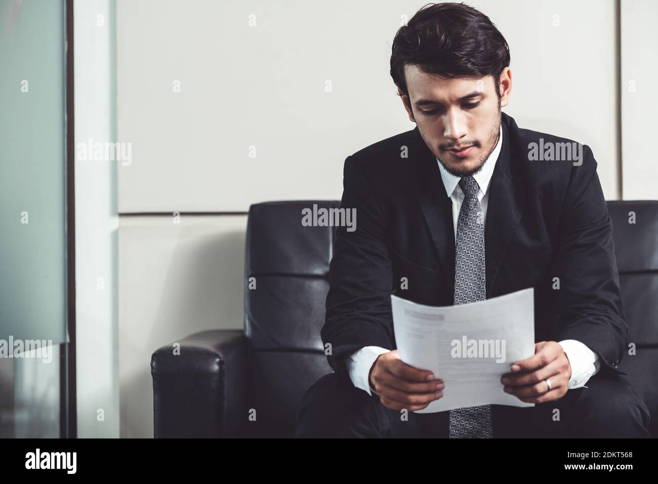 Stressed businessman candidate sit and wait for interview at the company office. Job application, business recruitment and Asian labor hiring concept. Stock Photo