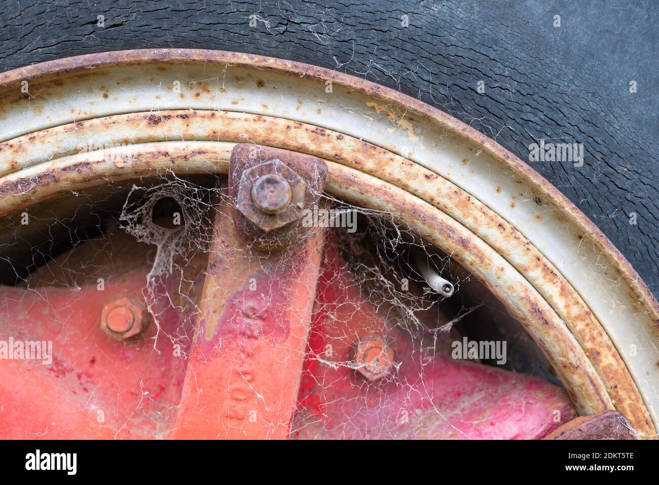 A close up of an old worn out truck wheel and perished tyre (tire) with cobwebs Stock Photo