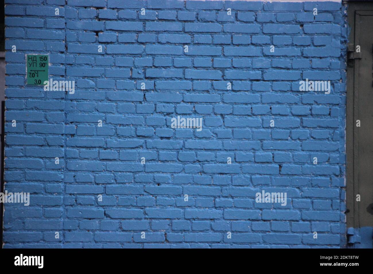 Old brick wall painted into solid blue. Stock Photo