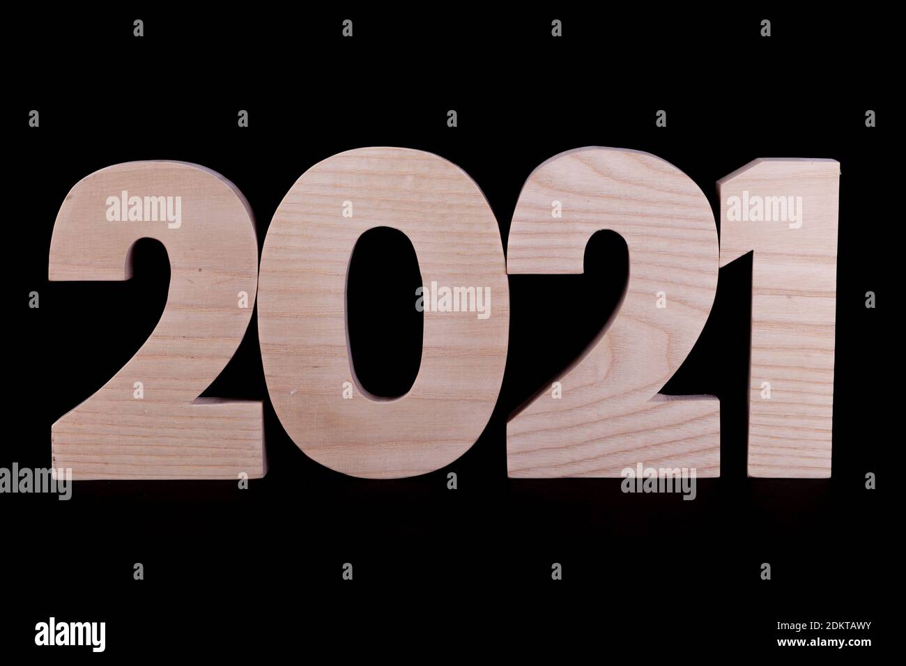 2021 year large wooden numbers squashed together. Hardwood characters on a black background Stock Photo