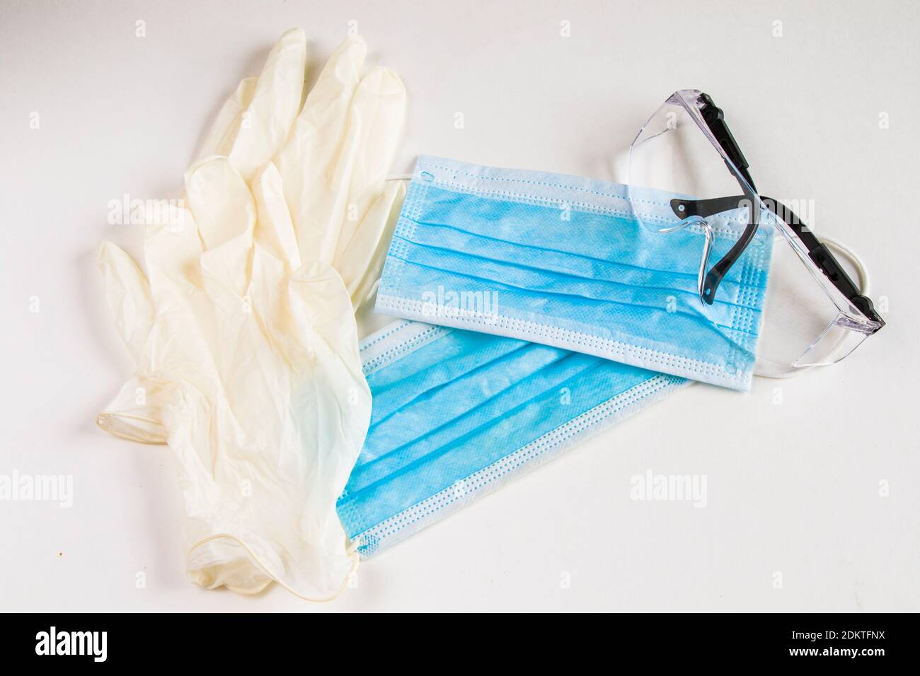 Medical gloves, face masks and safety glasses on the white background