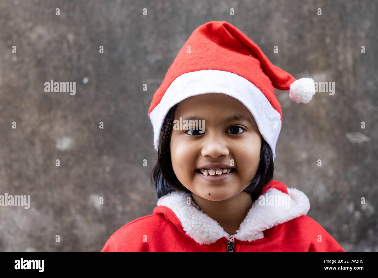 portrait of an Indian girl child smiling in santa claus dress and