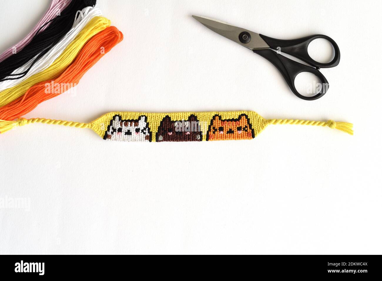 Woven DIY friendship bracelet with Cats pattern handmade of embroidery  floss on white background Stock Photo - Alamy