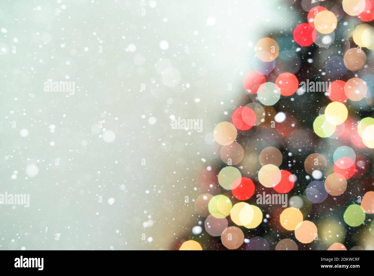 Part of blur Christmas tree lights decoration on blue background and snowflakes Stock Photo