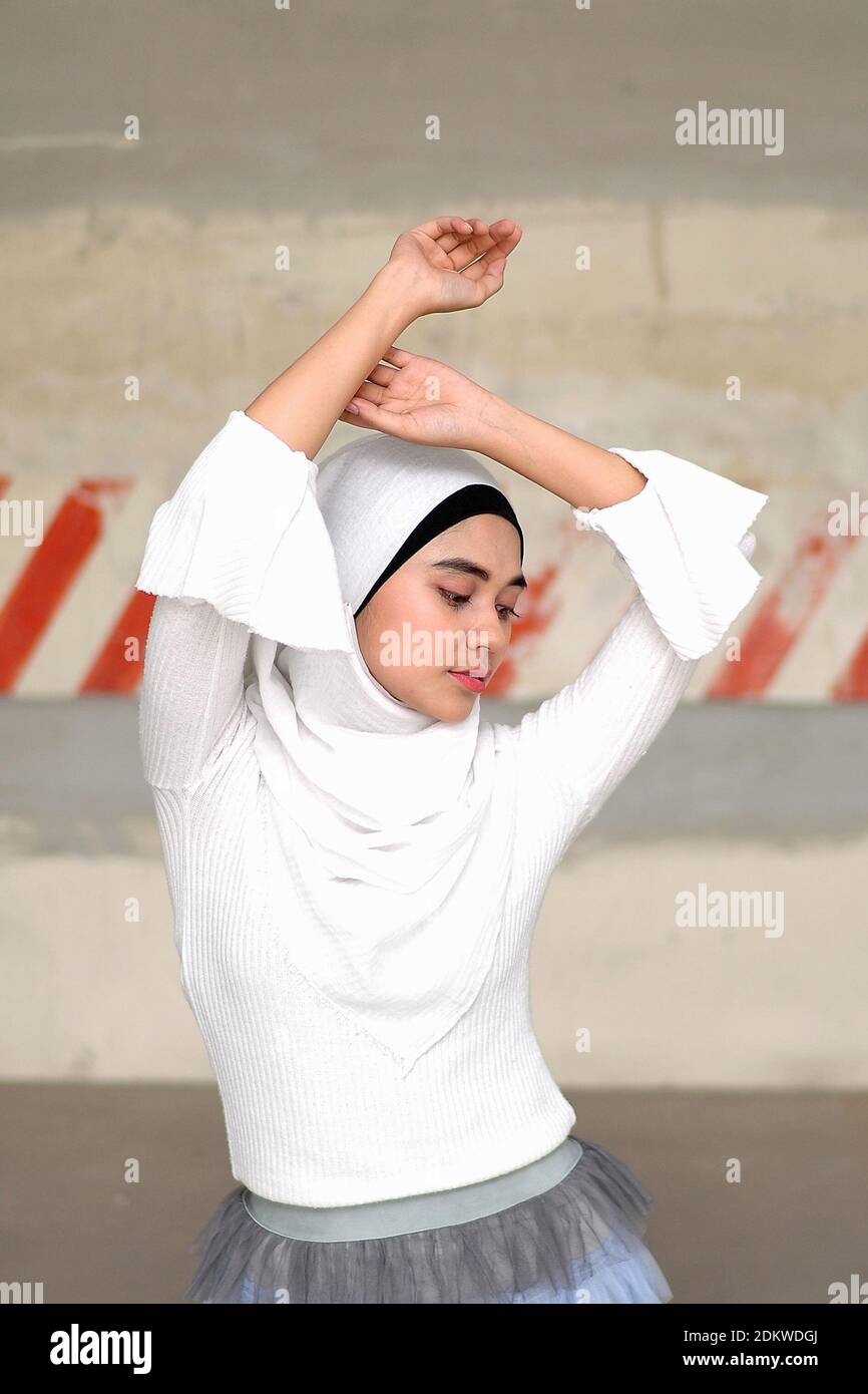 Woman With Arms Raised Standing Against Wall Stock Photo Alamy