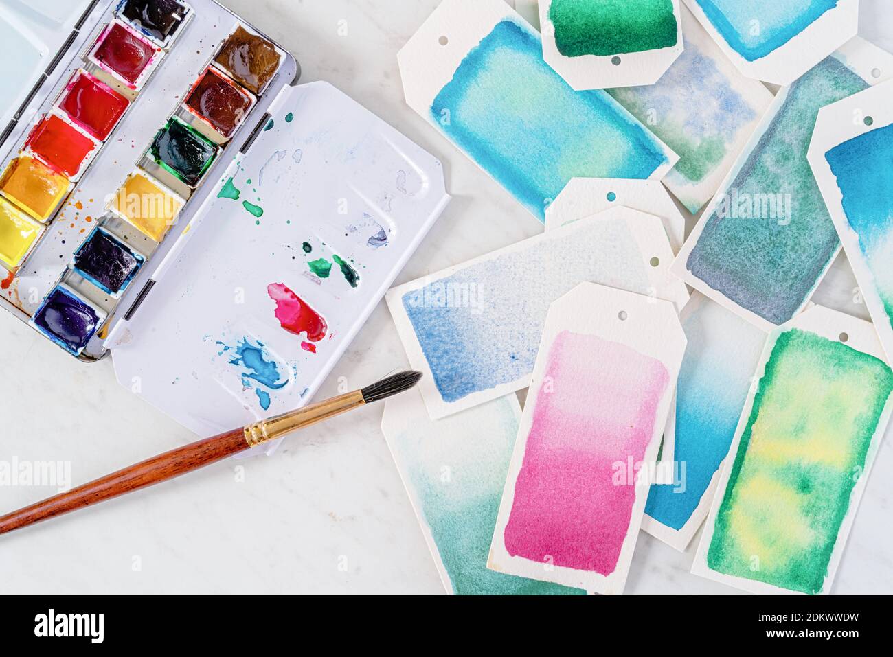 Homemade gift tags made out of watercolor paper and painted with watercolor paint in abstract free flowing designs. Stock Photo