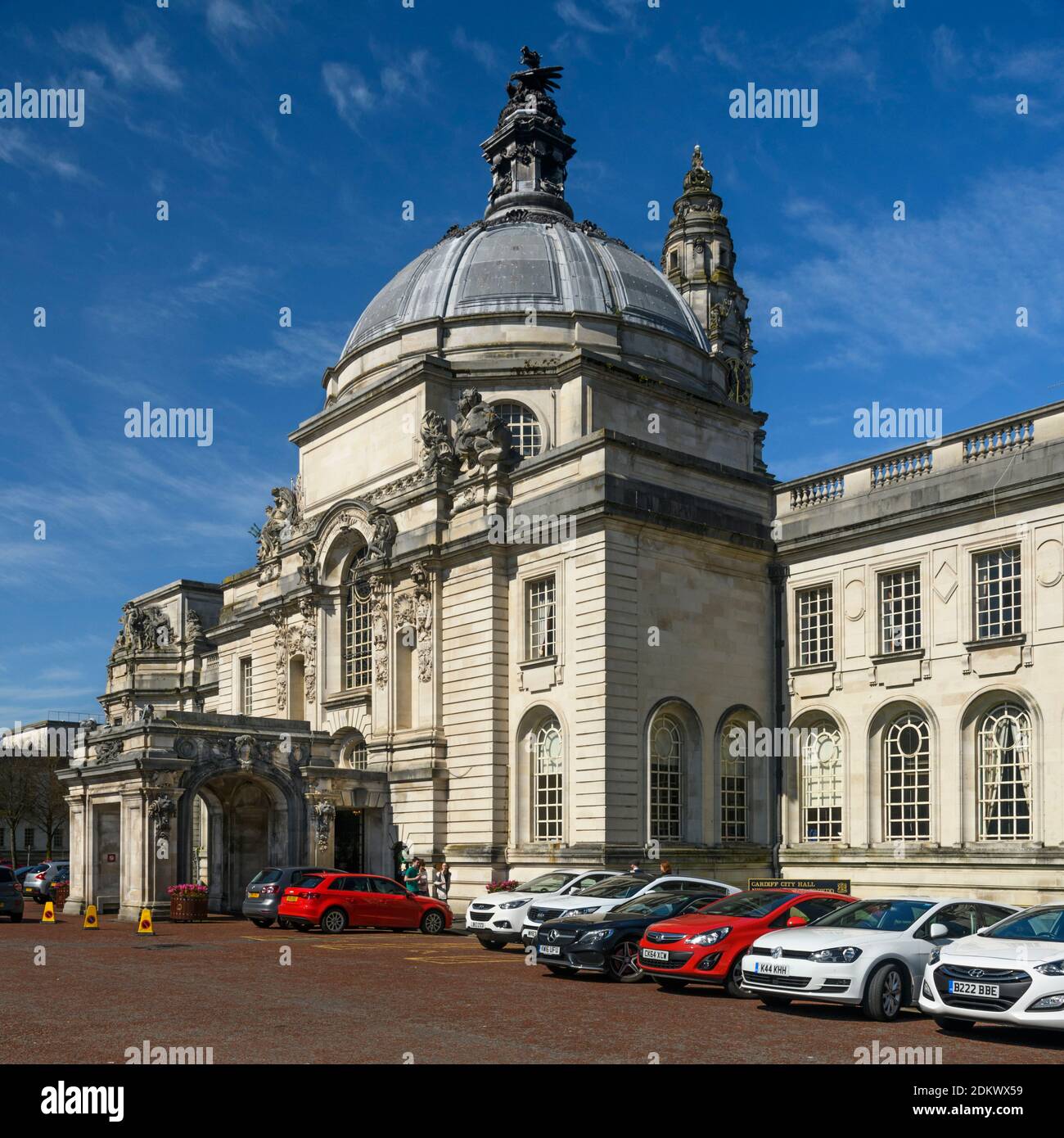City Hall in Cardiff exterior (grand historic civic centre landmark building, dome, clock tower, entrance portico, bright blue sky, cars) - Wales, UK. Stock Photo