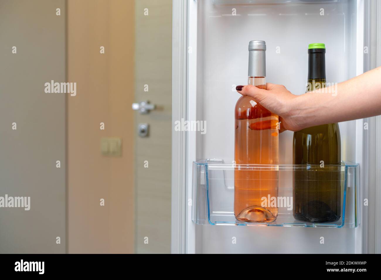 Female hand taking bottle of wine from a fridge Stock Photo Alamy