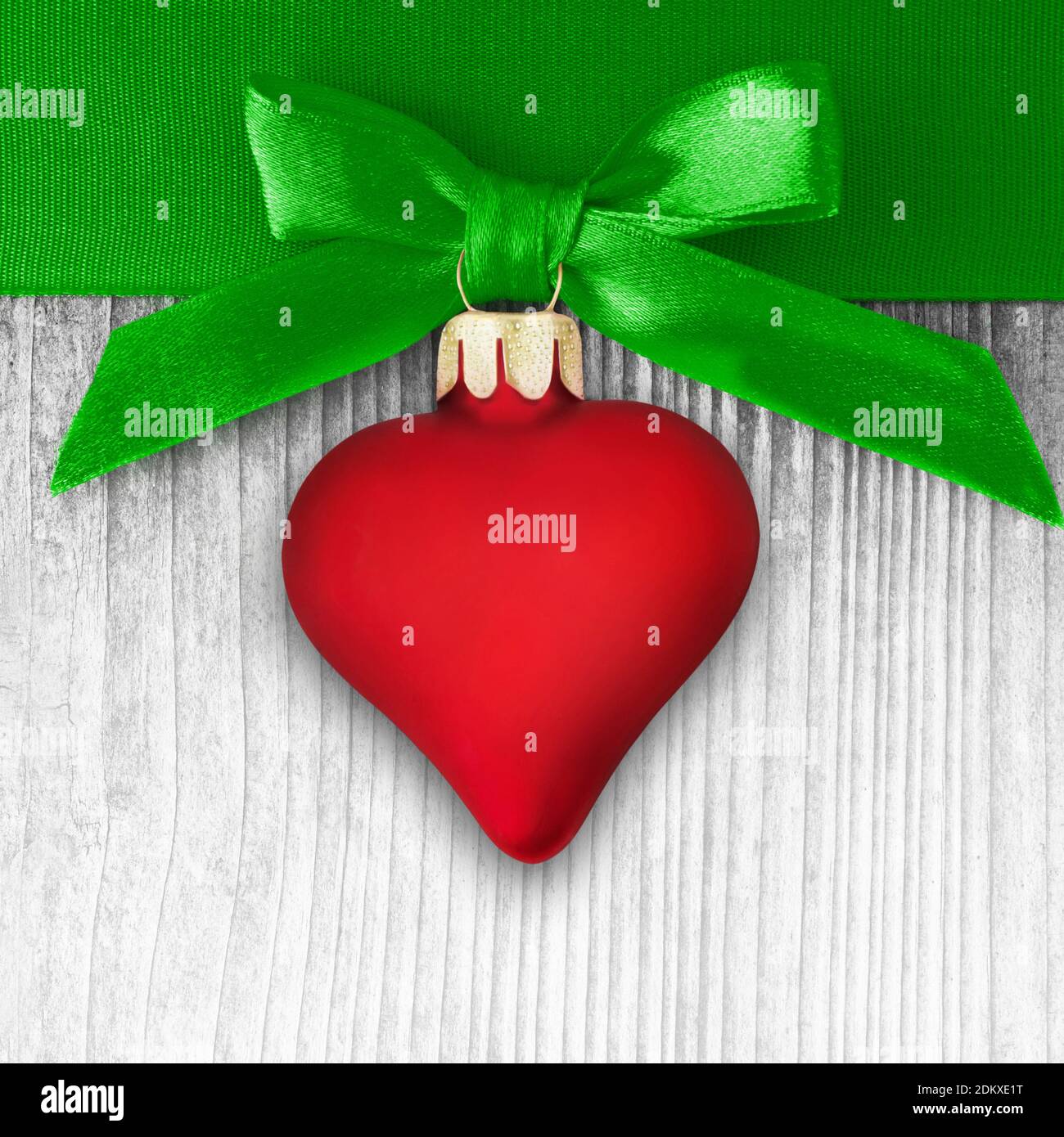 Red love heart and green ribbon on wooden background Stock Photo