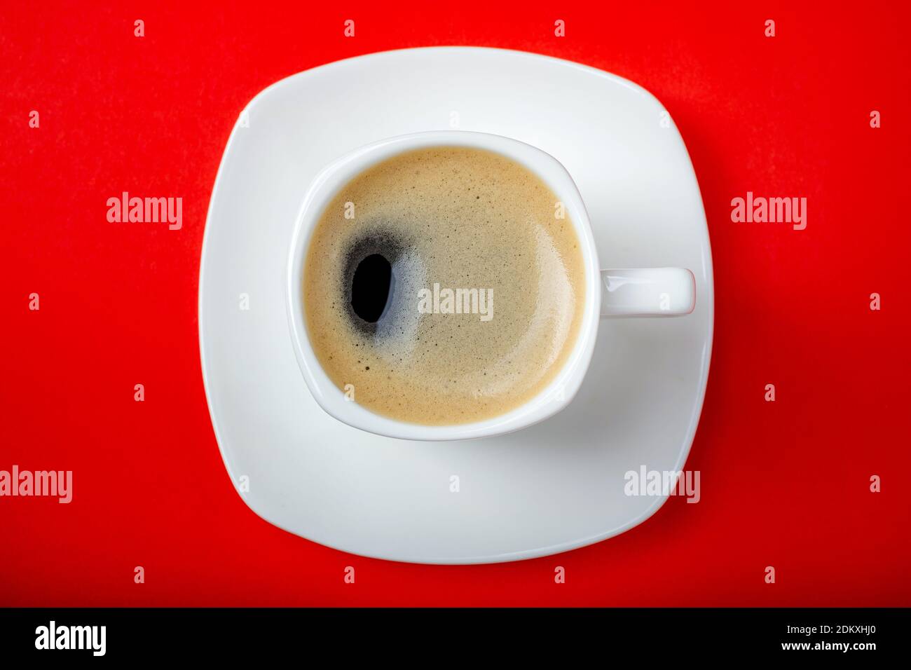 Coffee espresso in white cup. Coffee cup on red background closeup. Morning, breakfast, energy, coffee break concept. Top view Stock Photo
