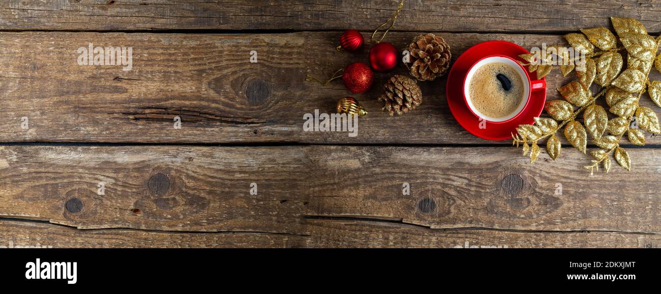 Christmas toys, red cup of coffee, decorations on wooden background. Christmas composition with aroma coffee cup. Winter holidays, Christmas, New Year Stock Photo