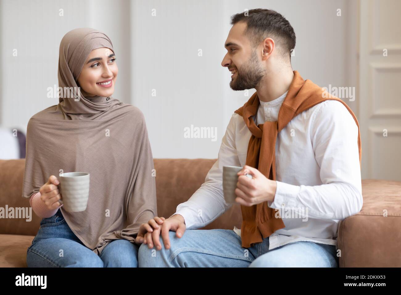Young Muslim Couple Talking And Flirting Drinking Coffee At Home Stock Photo