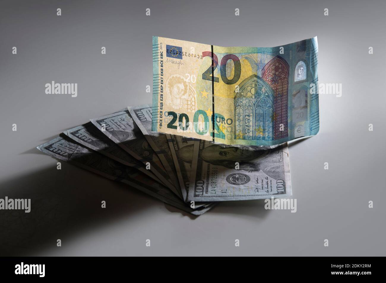 Twenty euro note on top of one hundred dollar bills Stock Photo