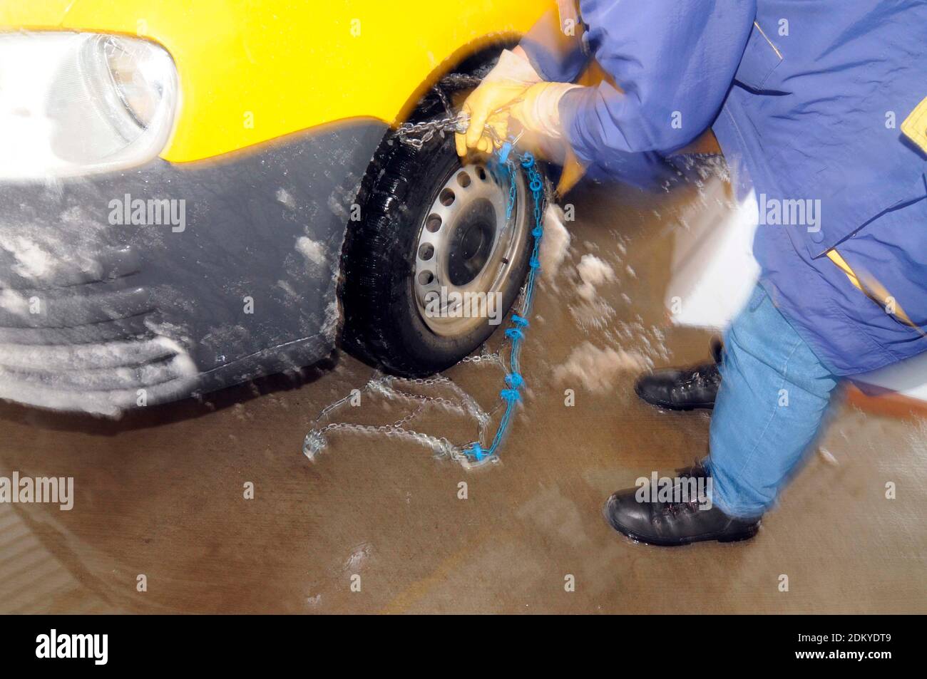 putting on snow chains on a car, road safety in winter Stock Photo Alamy