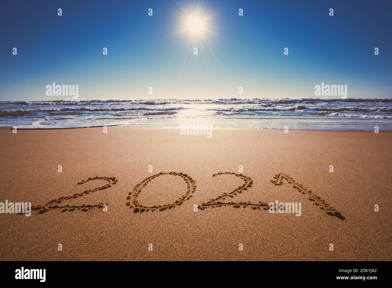 Happy New Year 2021 concept, lettering on the beach. Written text on the sea beach at sunrise. Stock Photo