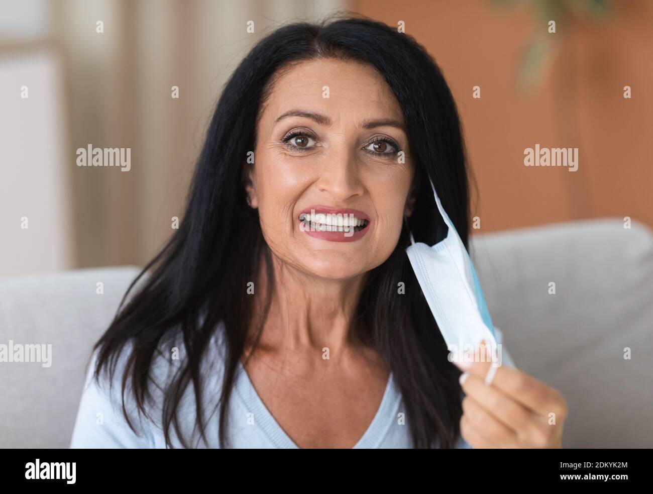 Portrait of mature woman taking off surgical face mask Stock Photo Alamy