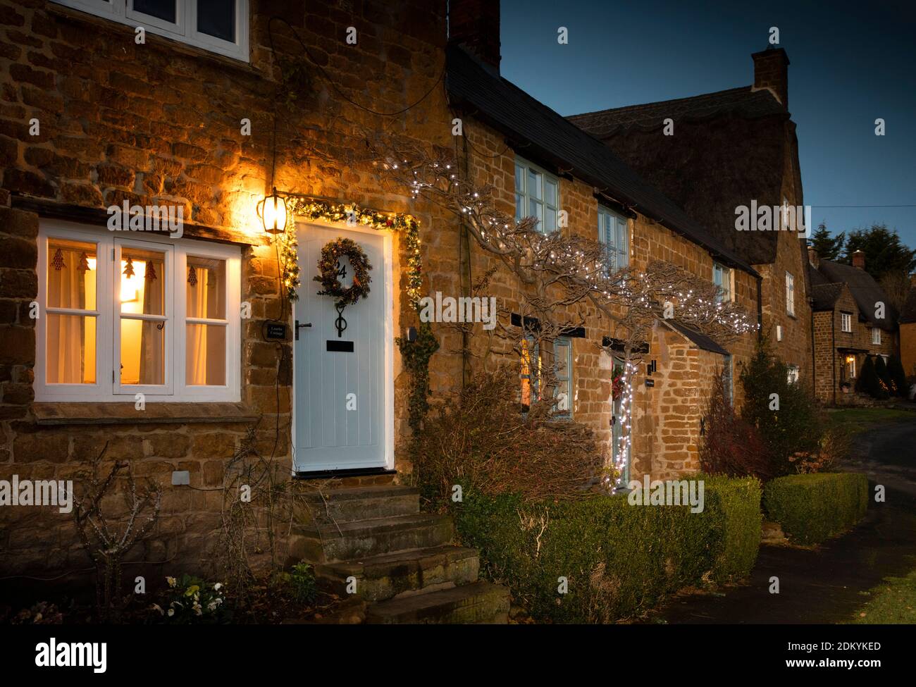 UK, England, Oxfordshire, Banbury, Wroxton, cottages around village green illuminated for Christmas Stock Photo