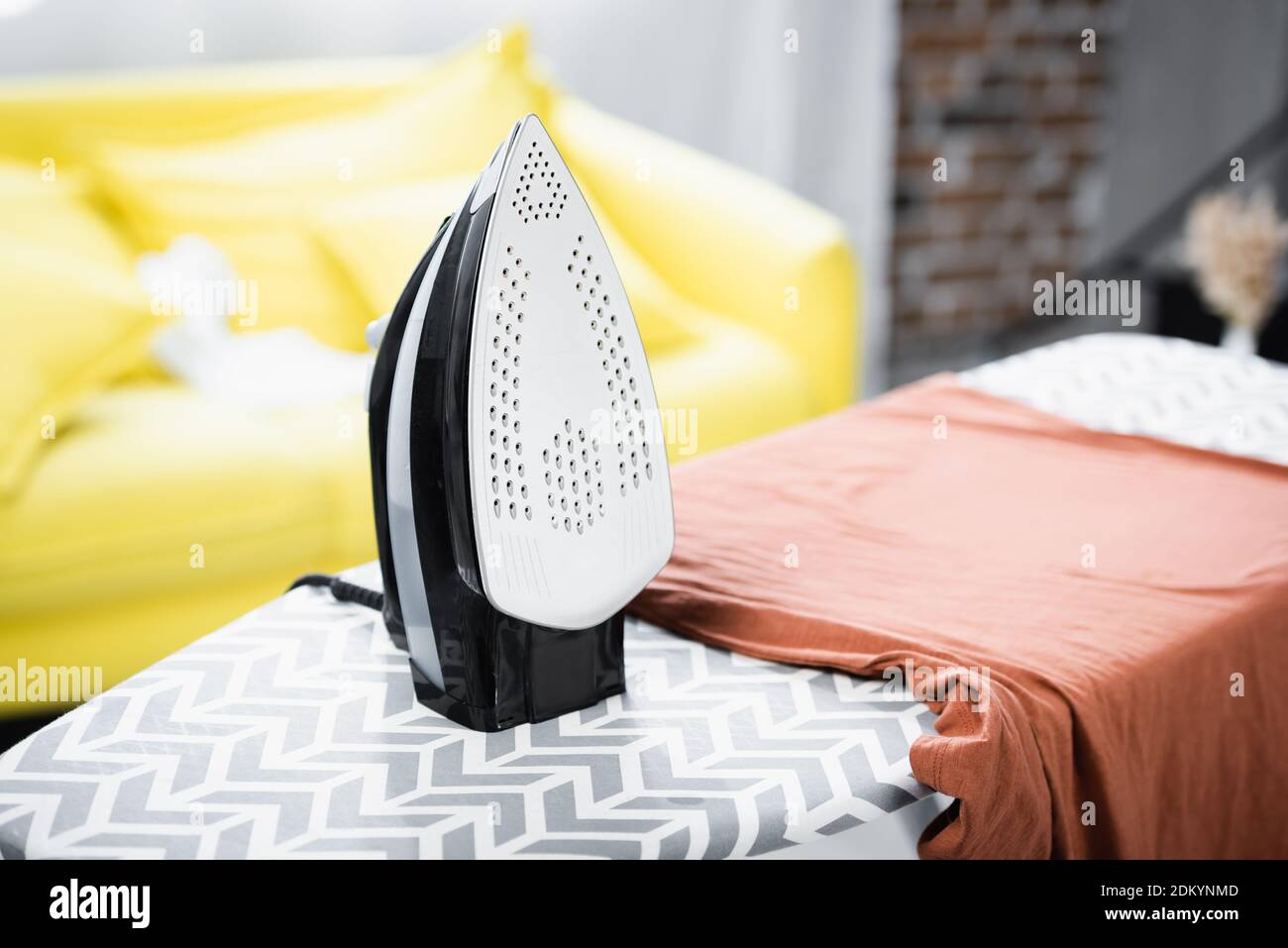 Iron near clothes on board on blurred background Stock Photo Alamy