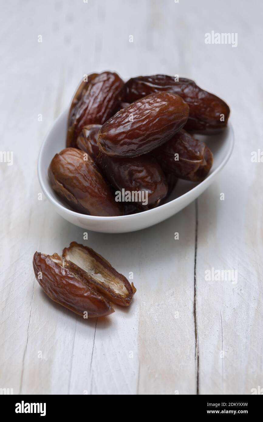 Dried dates on white wooden background. Stock Photo