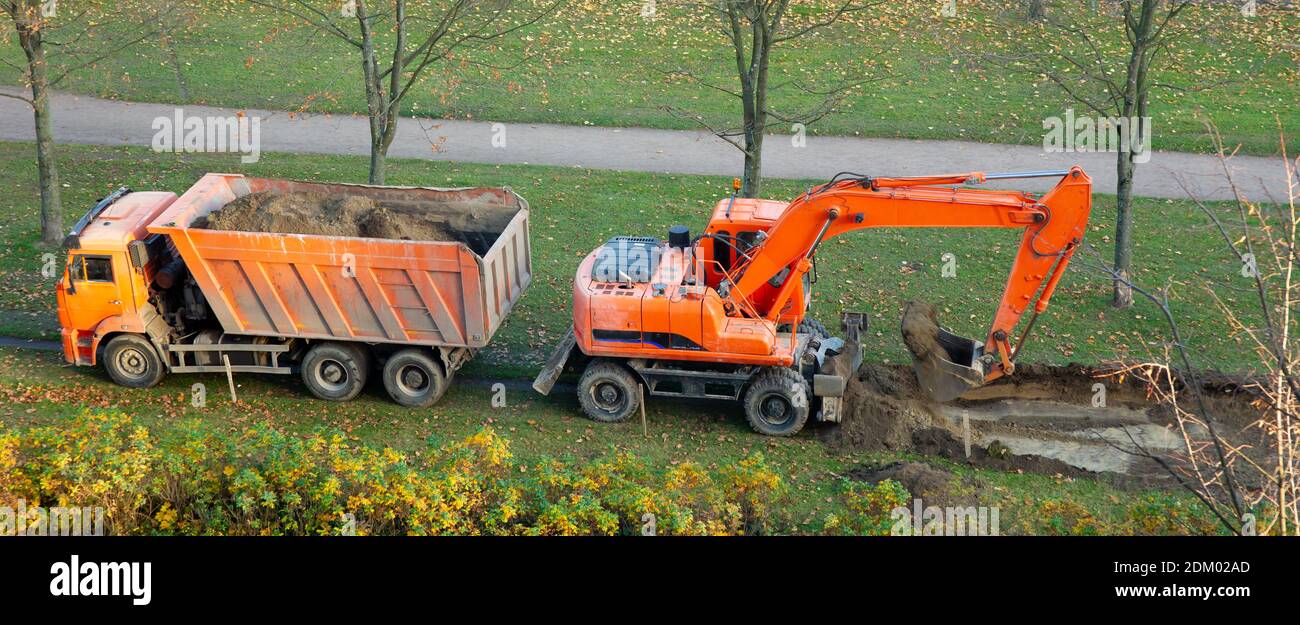 excavator and dump truck. work on the arrangement of tracks Stock Photo