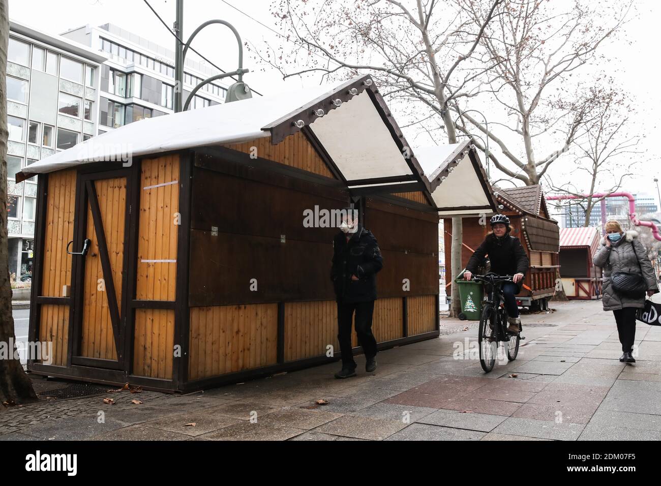 Berlin, Germany. 16th Dec, 2020. Pedestrians walk past closed Christmas  chalets in Berlin, capital of Germany, Dec. 16, 2020. Germany will go into  stricter lockdown from Wednesday, closing non-essential shops and limiting