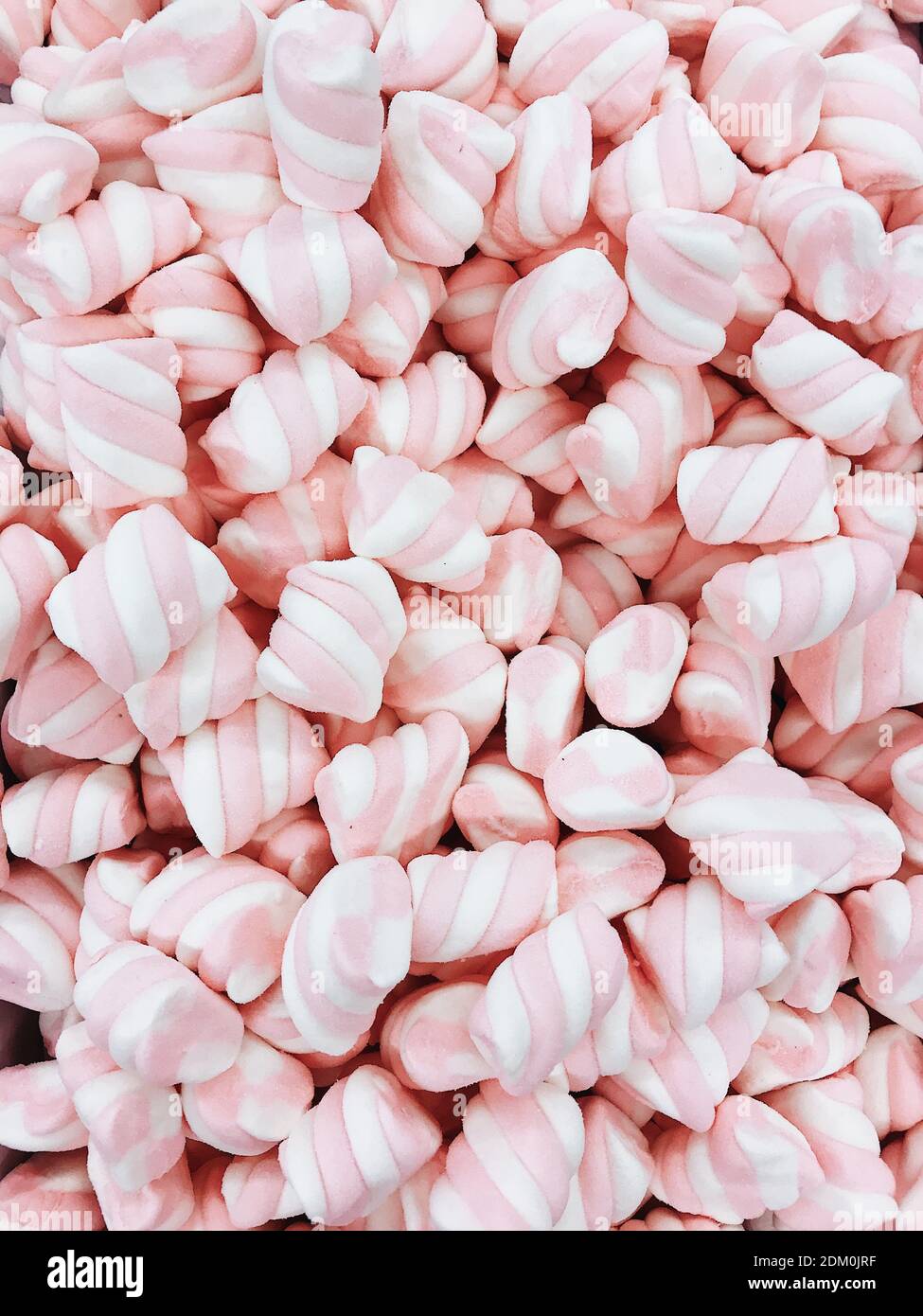Many marshmallow sweet candies, striped with pink and white. Chewy