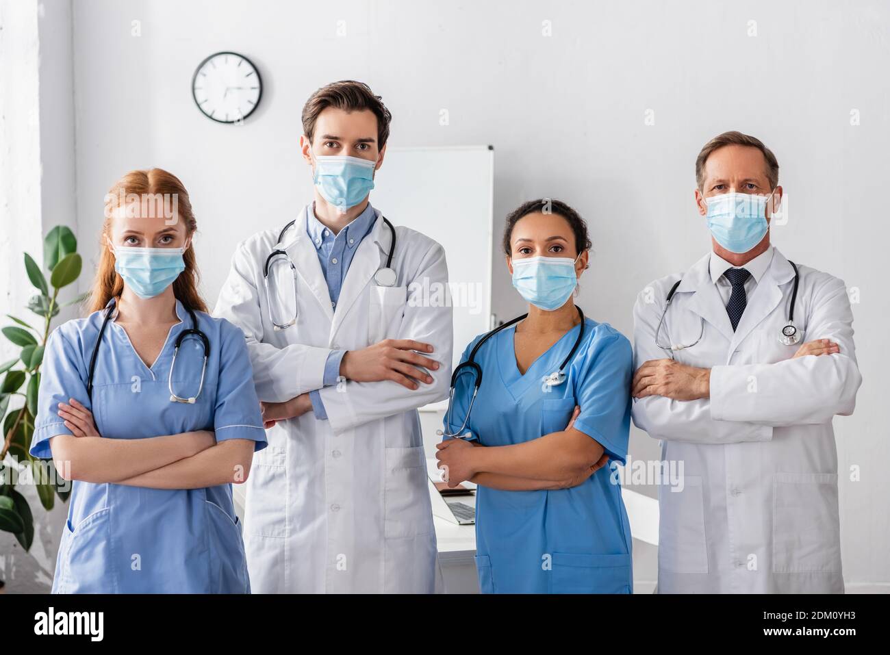 Multicultural doctors and nurses in medical masks with crossed arms ...