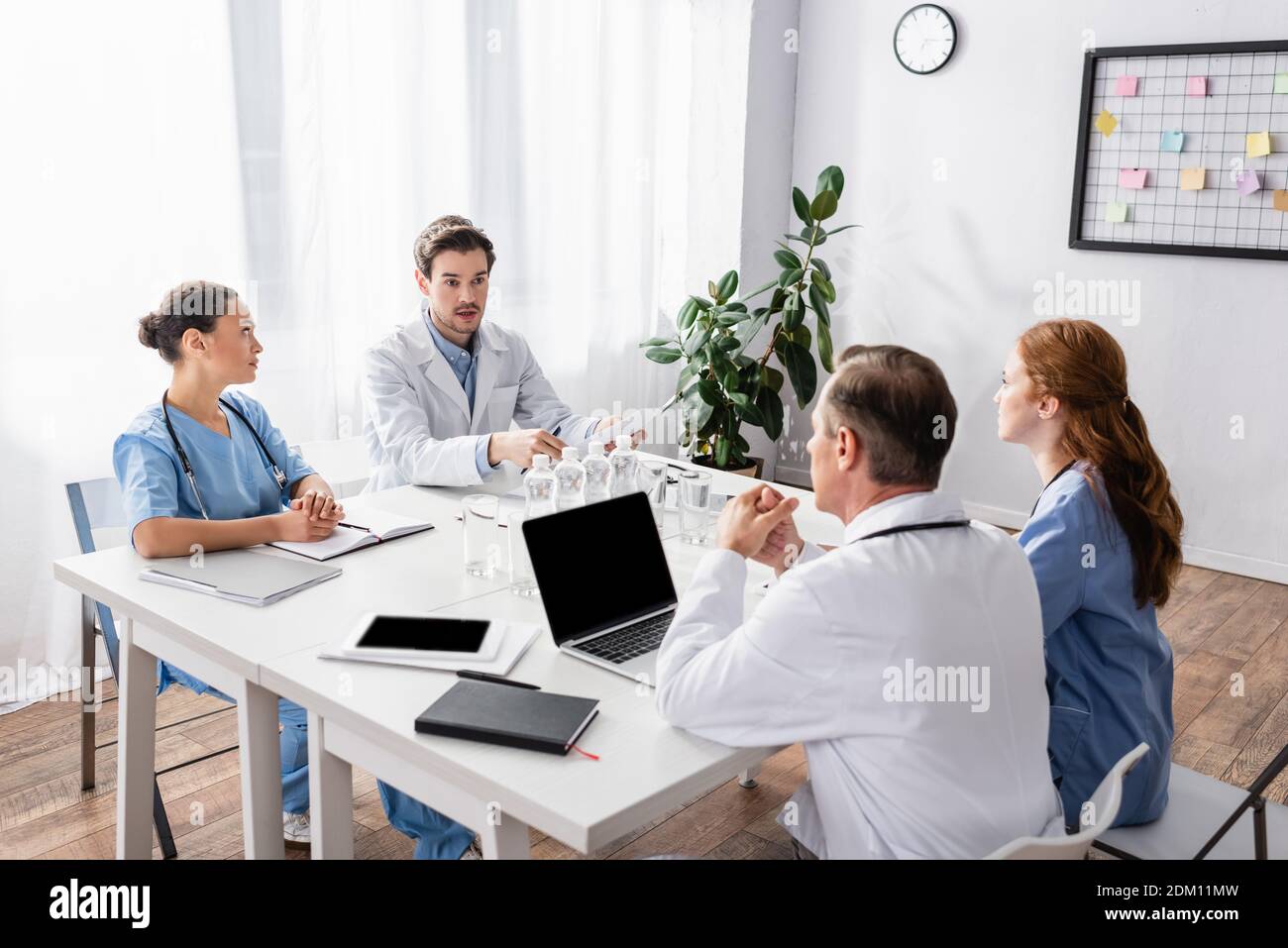 Multicultural doctors and nurses working with papers and devices in ...