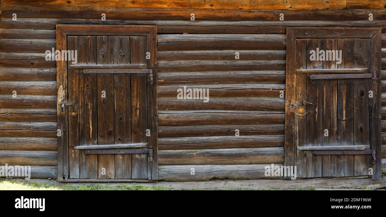 Two wooden doors in an old log building. Front view. Texture background ...