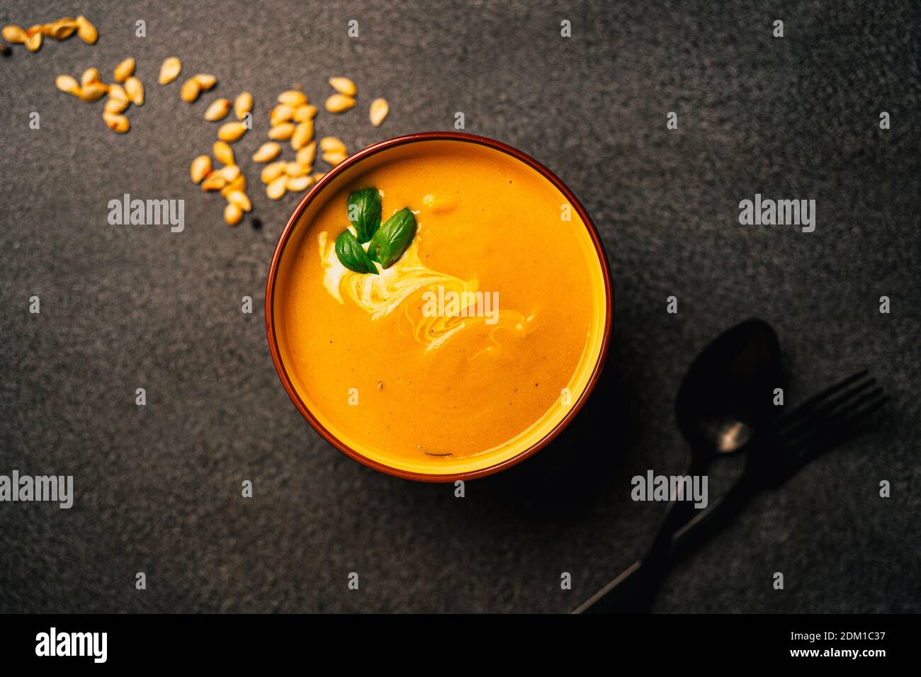 Served creamy bright orange butternut squash soup. Creamed blended yellow and orange vegetables, rich in carotene.Pumpkin seeds.Delicious homemade die Stock Photo