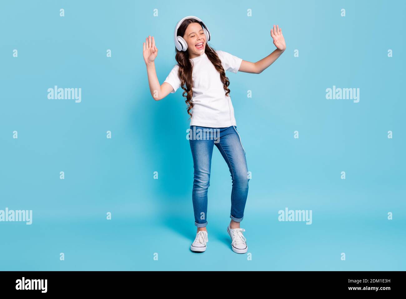 Full length body size view of nice dreamy cheerful wavy-haired girl listening stereo single melody having fun dancing isolated on bright vivid shine Stock Photo