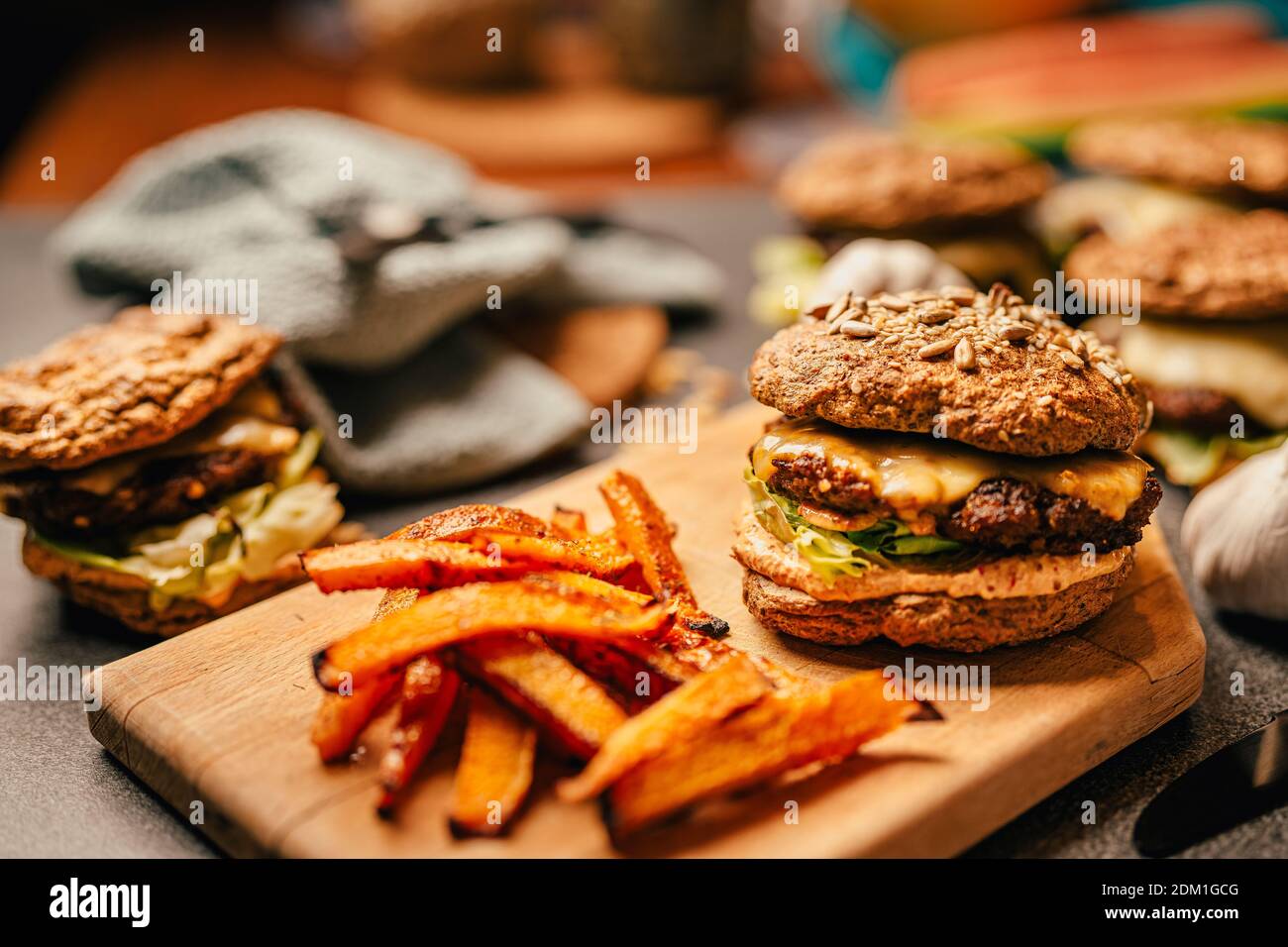 Homemade low carb diet hamburger with seed flour buns and pumpkin fries.Diet burgers with sugar-free sauce, mayonnaise, lettuce, and melted cheese.Bee Stock Photo