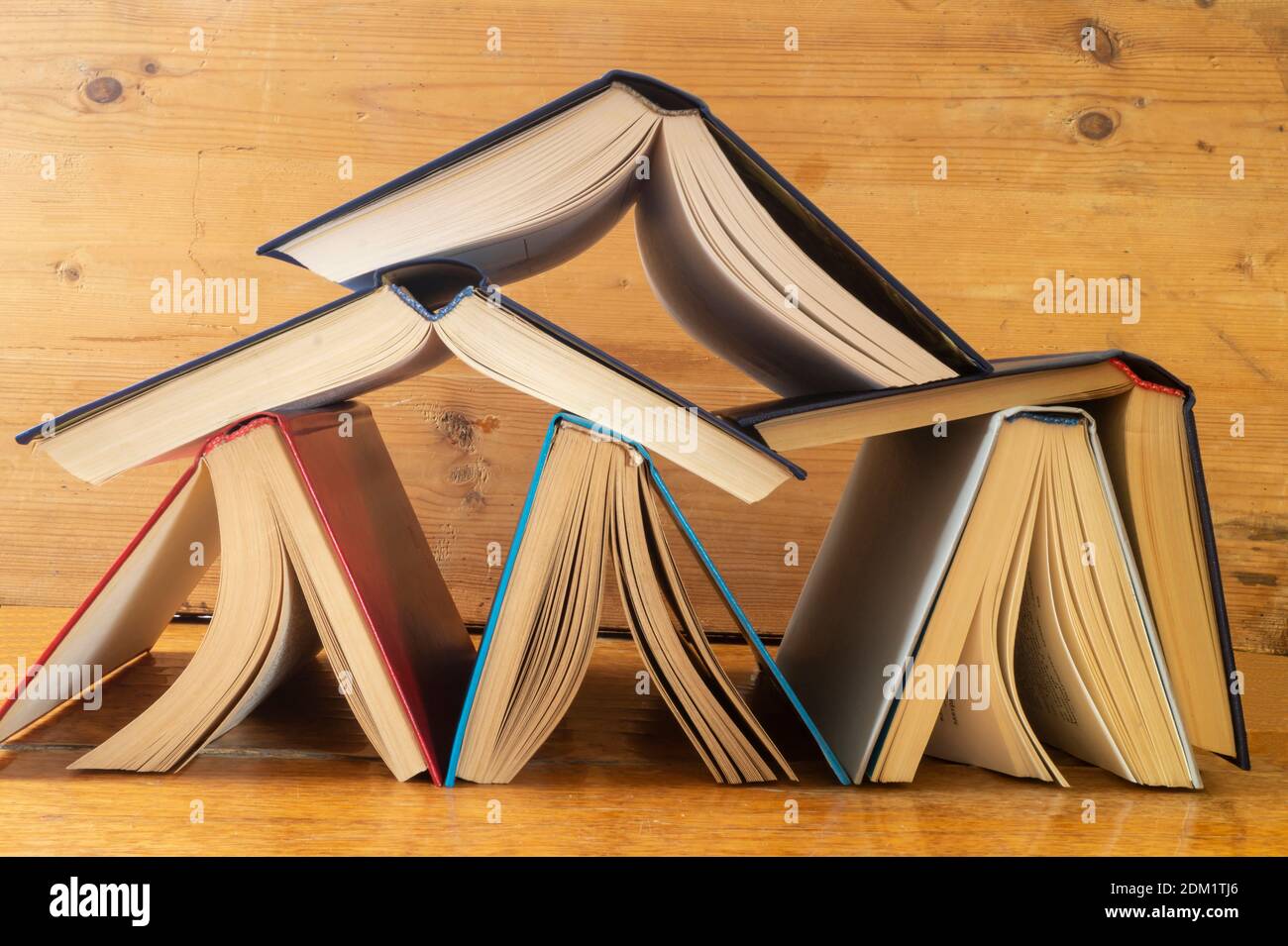 The Stack of the books rests upon wooden regiment. Subjects in closet close-up Stock Photo