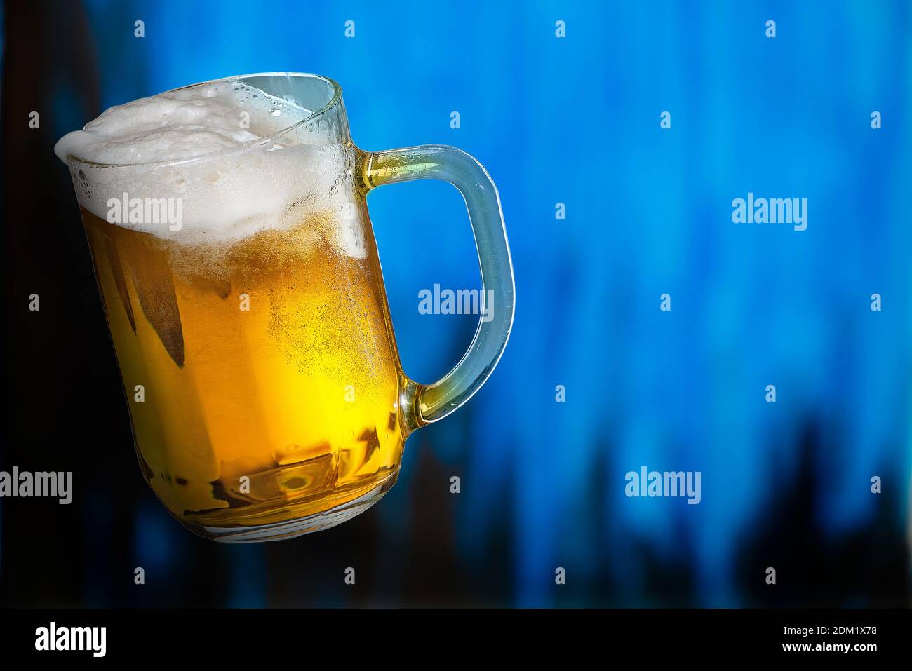 Two tall elegant pint glasses of cold wheat beer with a frothy head on a  wooden bar table conceptual of Oktoberfest Stock Photo - Alamy