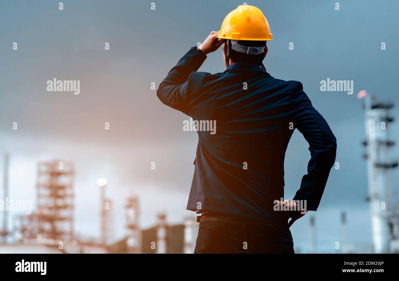 Rear View Of Architect Wearing Hardhat Standing Against Sky In City Stock Photo