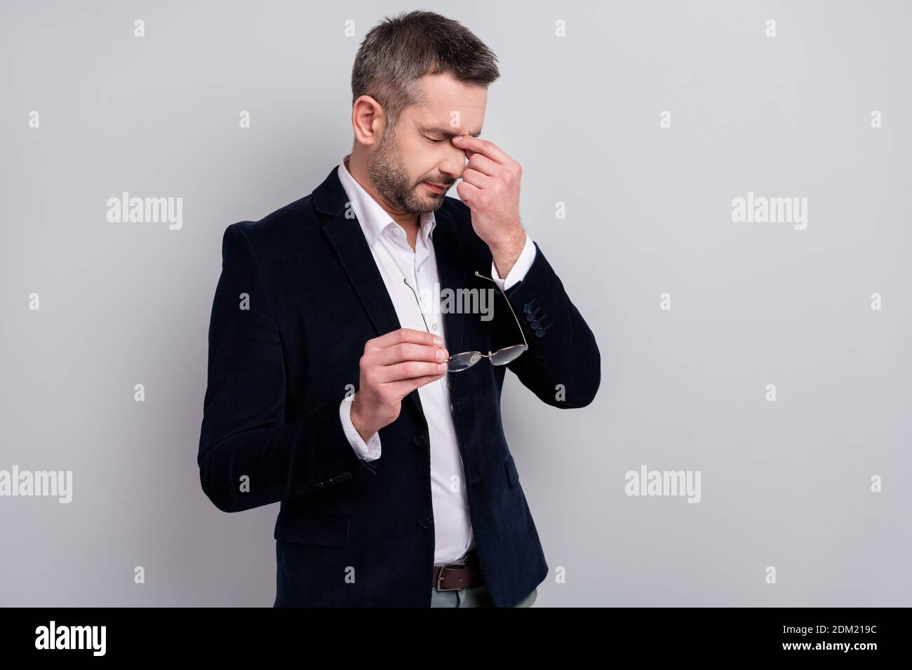 Portrait of his he nice attractive sad tired mature man entrepreneur wearing classy look holding in hands specs touching nose suffering feeling bad Stock Photo