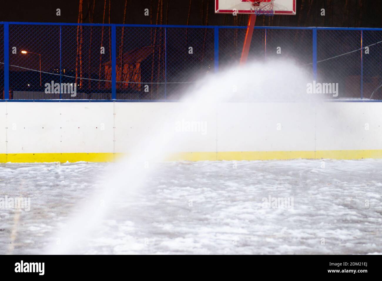 Filling the ice rink. Pouring a street roller through a hose Stock Photo Alamy