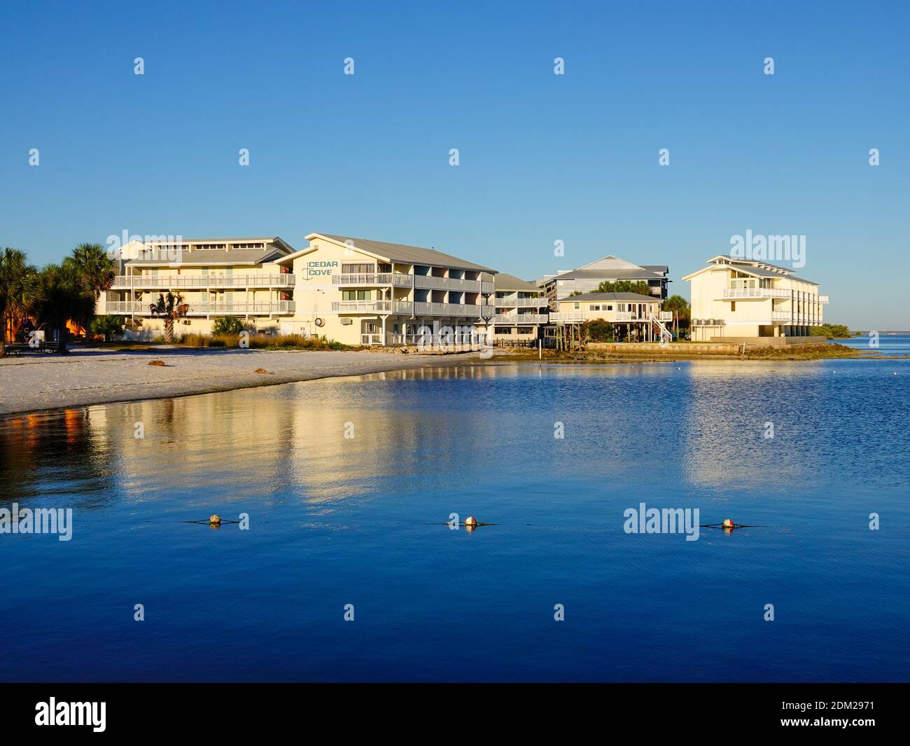 Cedar Key Hotel, clear blue skies and calm water frame waterside island beach resort on Cedar Key, Florida, USA. Stock Photo