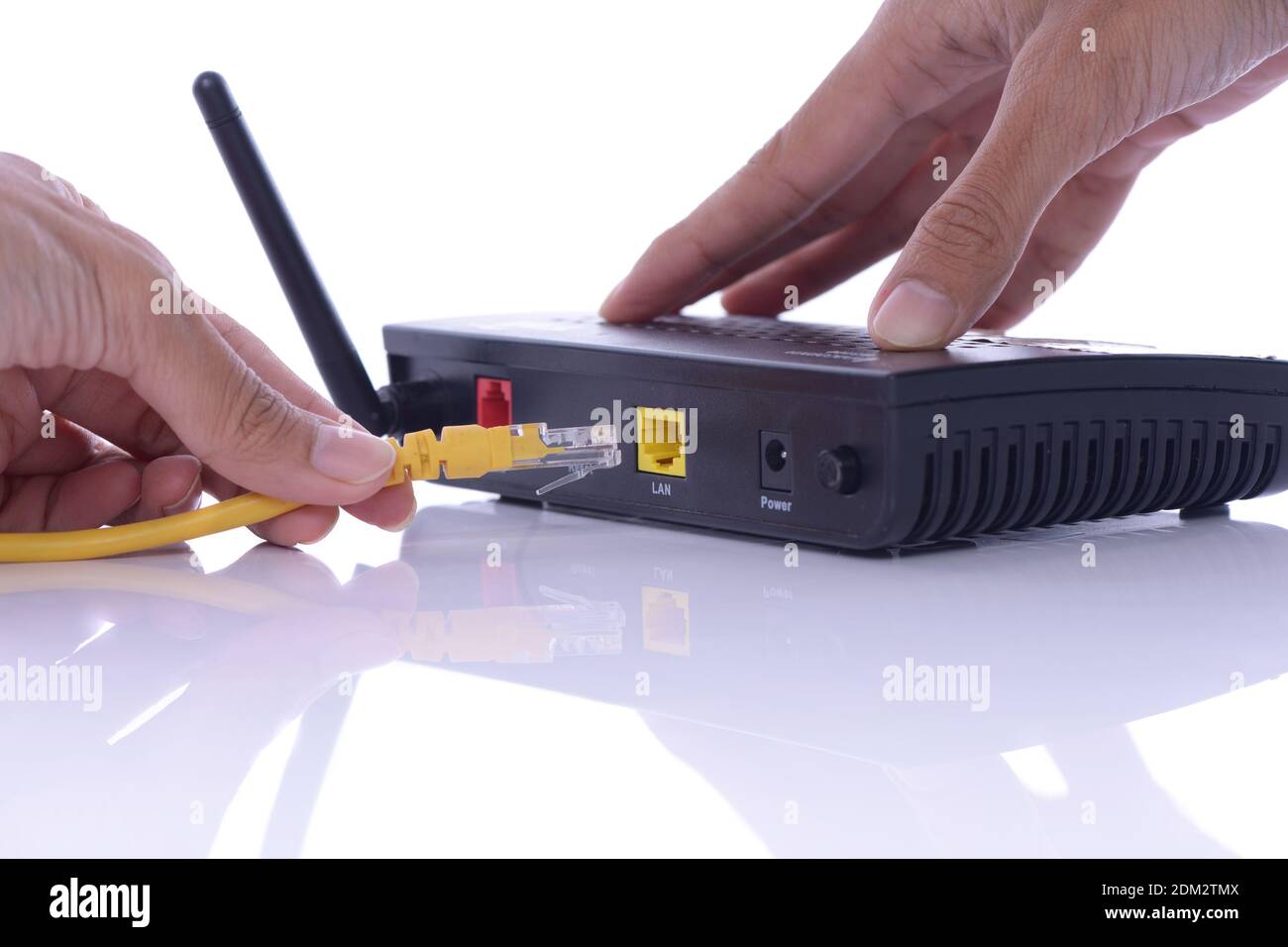 Cropped Hand Of Person Holding Cable By Router Against White Background  Stock Photo - Alamy