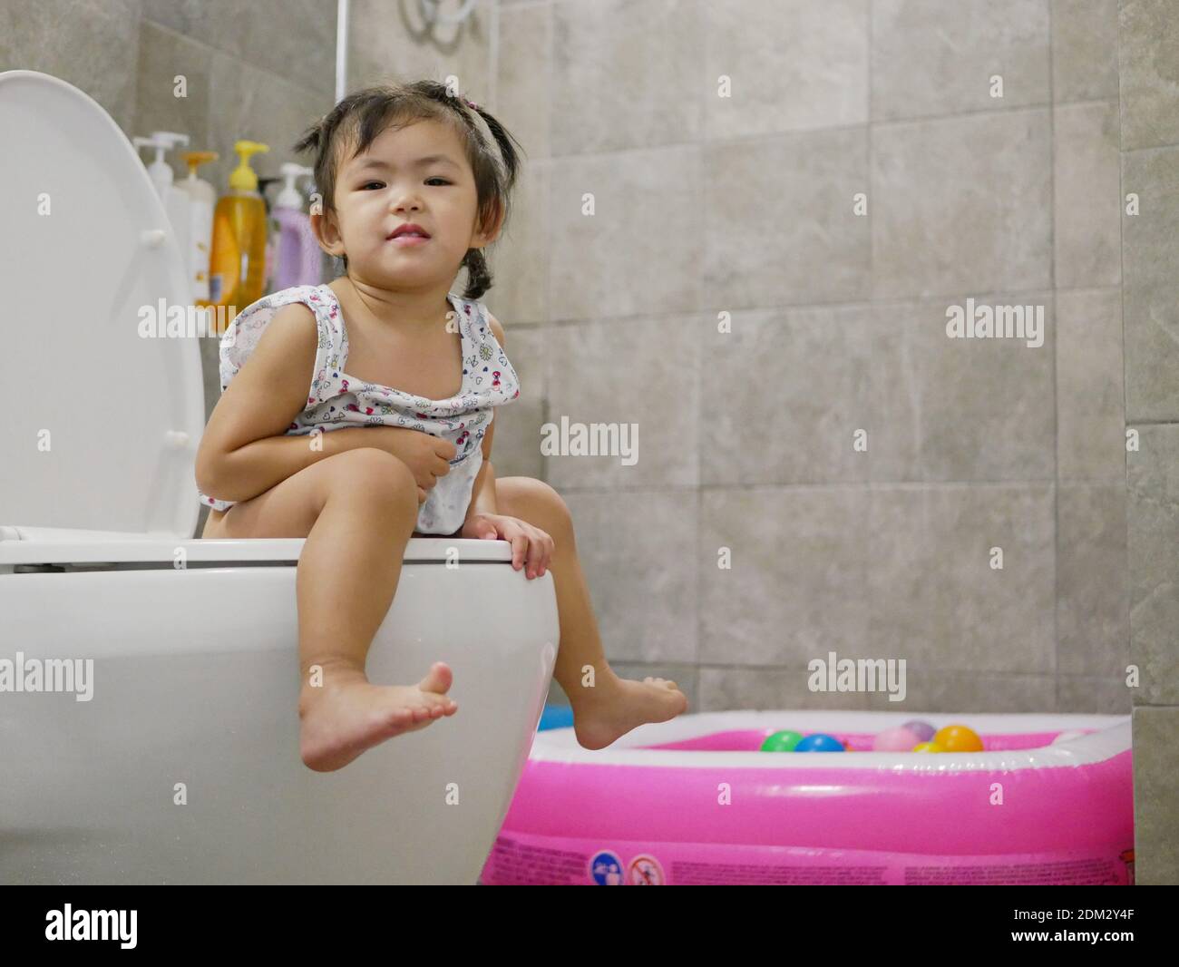 Portrait Of Cute Girl Using Toilet Bowl At Home Stock Photo - Alamy