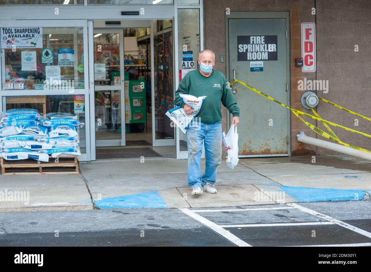 Southampton, Pennsylvania, UK. 16th December, 2020. Jim Long of Churchville carries rock salt in preparation for a major snowstorm in the Northeast Wednesday, December 16, 2020 at True Value in Richboro, Pennsylvania. Credit: William Thomas Cain/Alamy Live News Stock Photo