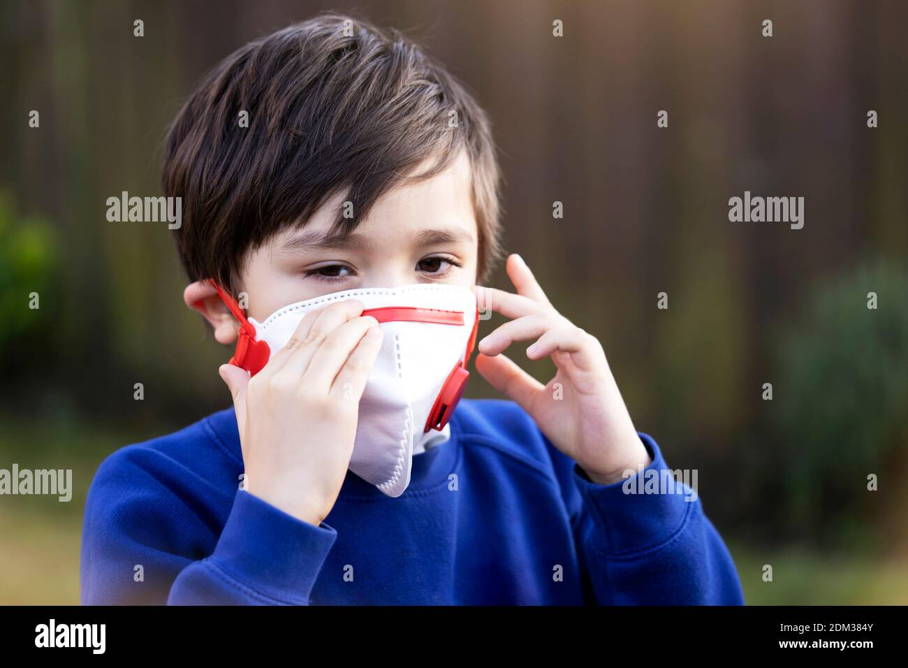 Portrait Of Cute Boy Wearing Mask Standing Outdoors Stock Photo Alamy