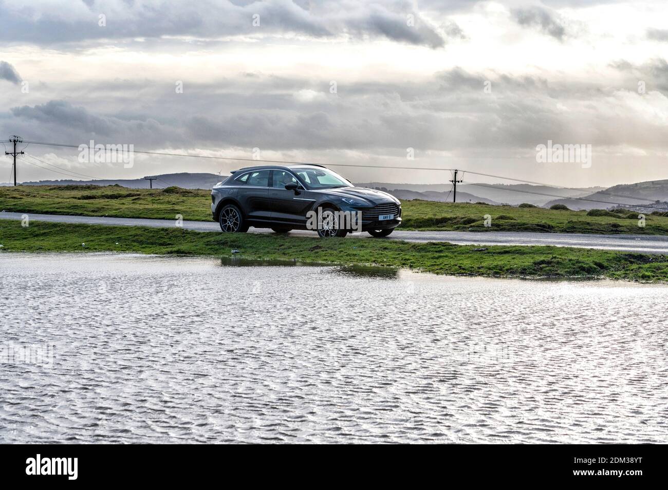 An Aston Martin DBX 4 litre V8 SUV with a top speed of 180 mph and a price tag starting at £158,000 pictured on the mountain tops in South Wales. Stock Photo