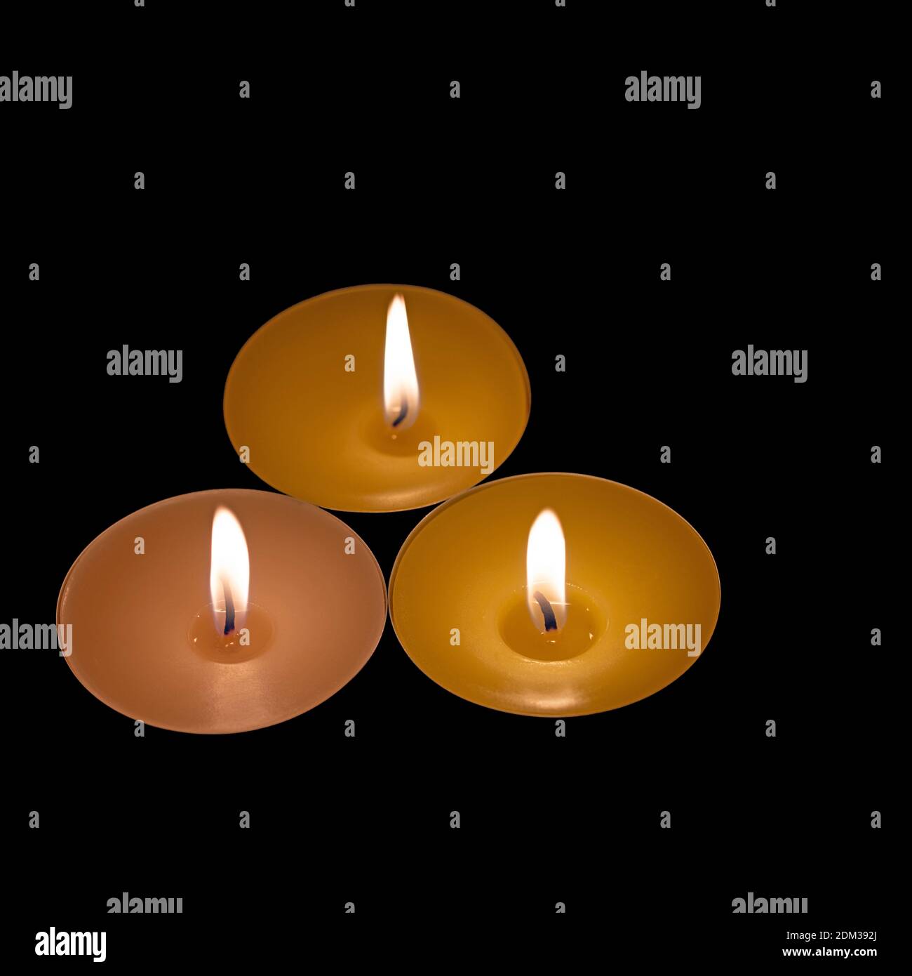 Three tea lights against a black background Stock Photo Alamy