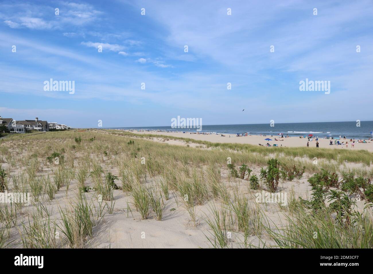 Landscape view of a beach in Long Beach Island in the middle of the summer with sand, sun, clouds, and dunes. Stock Photo