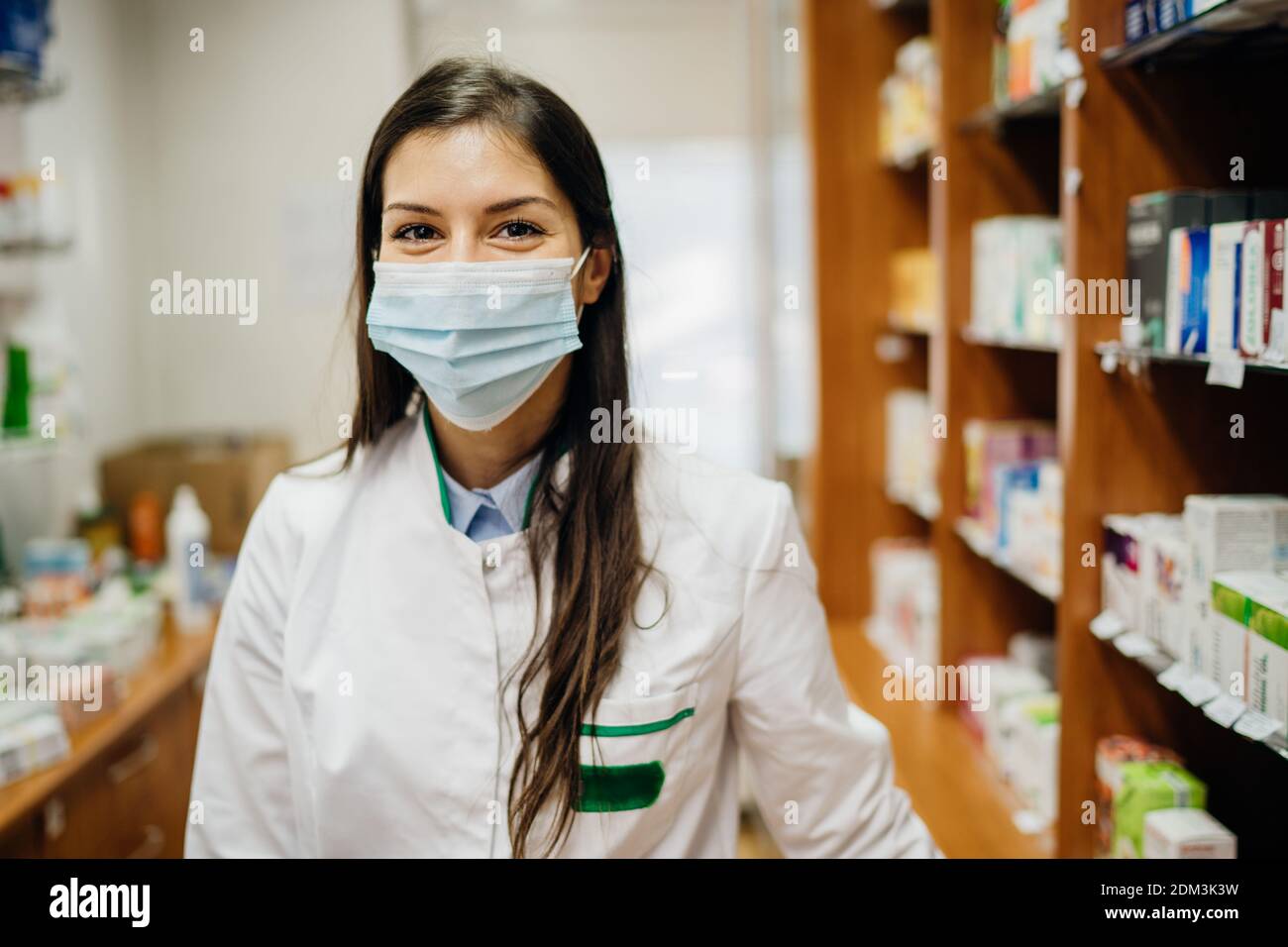 Friendly pharmacist working in a pharmacy amid coronavirus pandemic.Pharmaceutical health care professional providing COVID-19 therapy support.MPharm Stock Photo