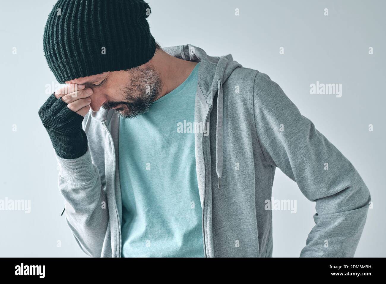 Letdown disappointed casual male in disbelief, adult caucasian male overwhelmed by disappointment looking down and sulking Stock Photo