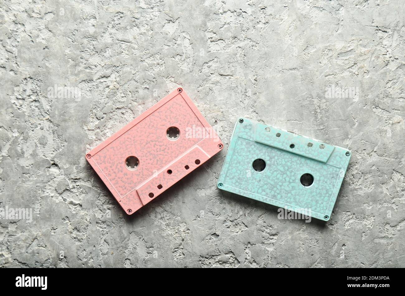 Blue and pink pastel audio cassettes on a gray concrete background. Top view, copy space Stock Photo