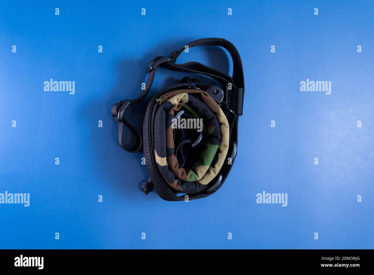 A top view of a camouflage military strap on a blue background Stock Photo