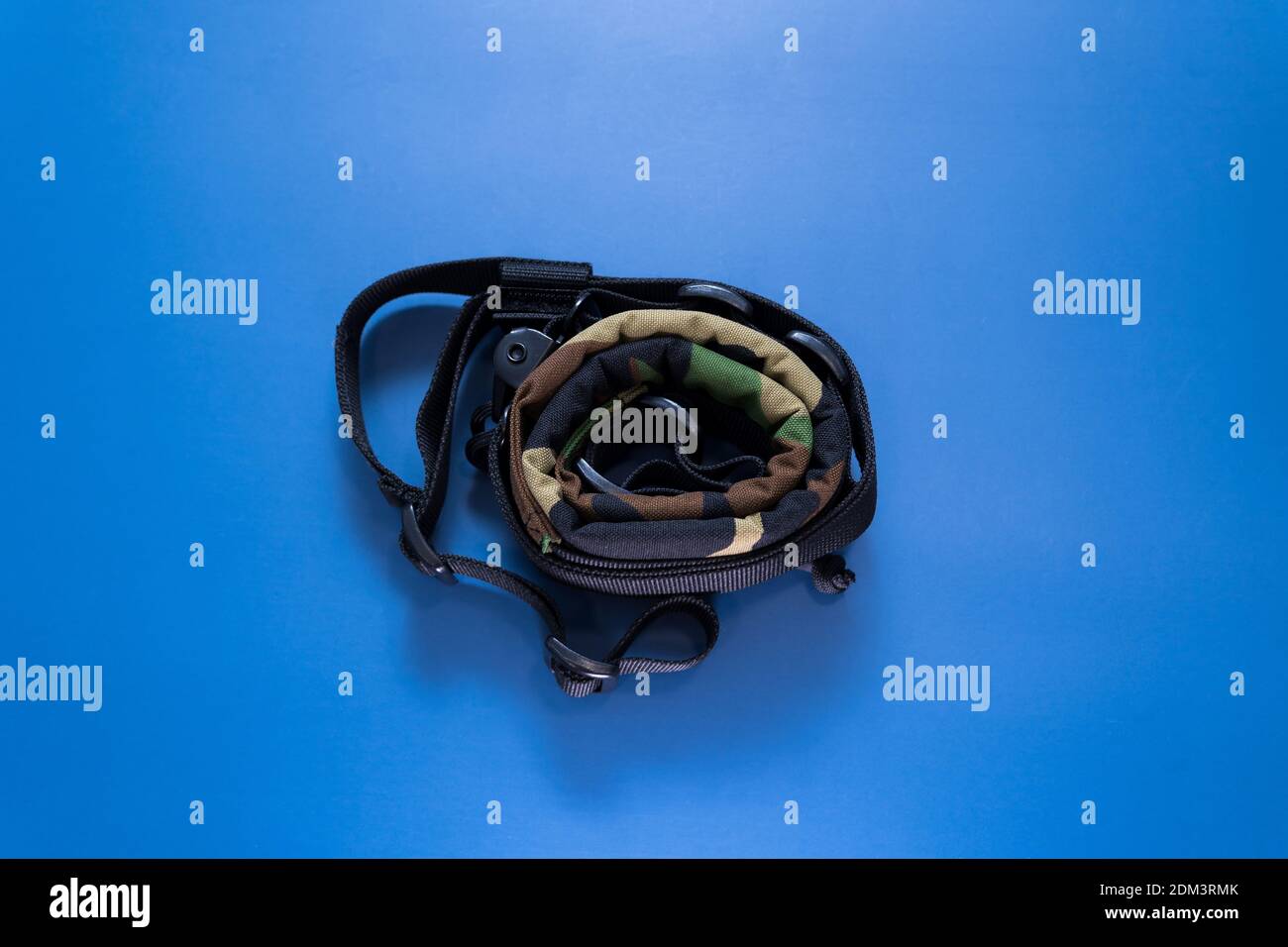 A top view of a camouflage military strap on a blue background Stock Photo